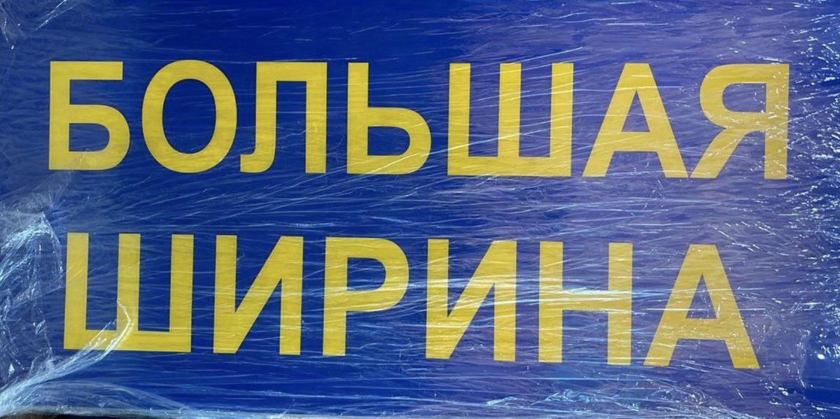 Синее табло с жёлтой надписью «БОЛЬШАЯ ШИРИНА» в две строки, в прозрачной плёнке